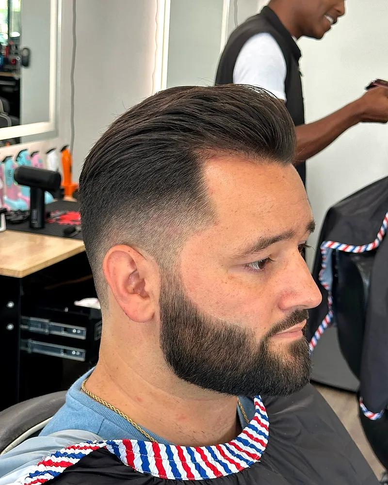 Sharp fade with a sculpted beard in profile